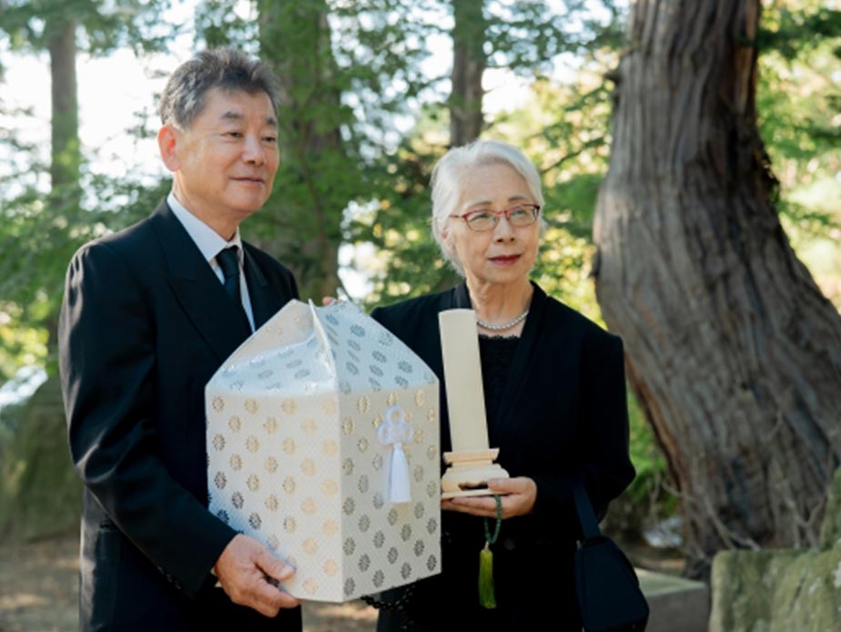 遺族が骨壷を抱えている様子